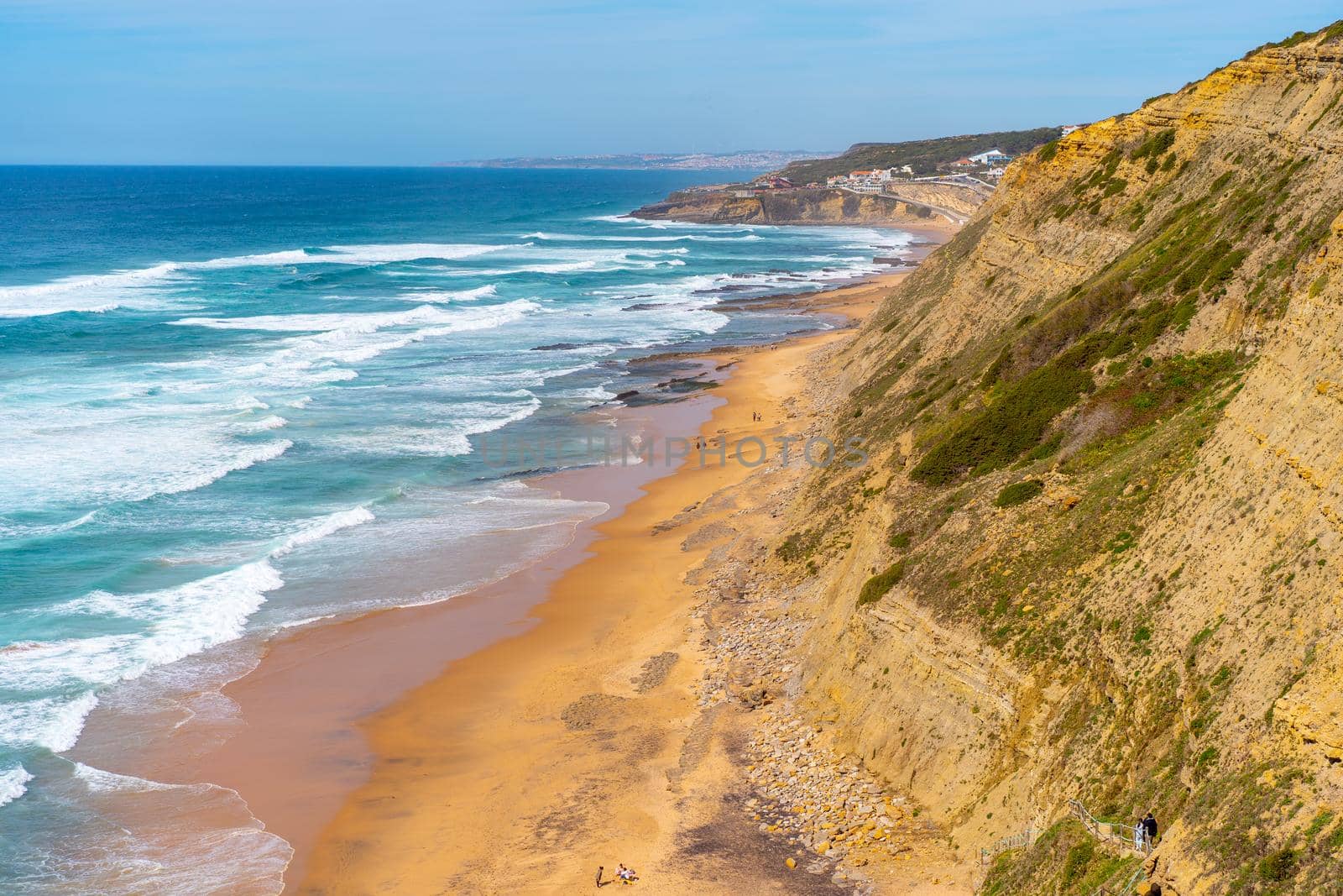 Aerial view of tropical sandy beach and ocean with turquoise water with waves. Sunny day on Atlantic ocean beach in Portugal