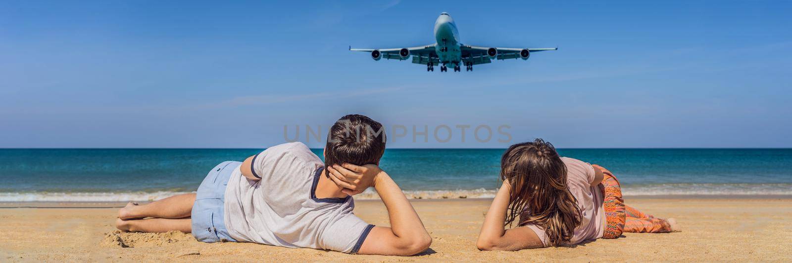 Man and woman tourists have fun on the beach watching the landing planes. Traveling on an airplane concept. Text space. Island Phuket in Thailand. Impressive paradise. Hot beach Mai Khao. Amazing landscape. BANNER, LONG FORMAT