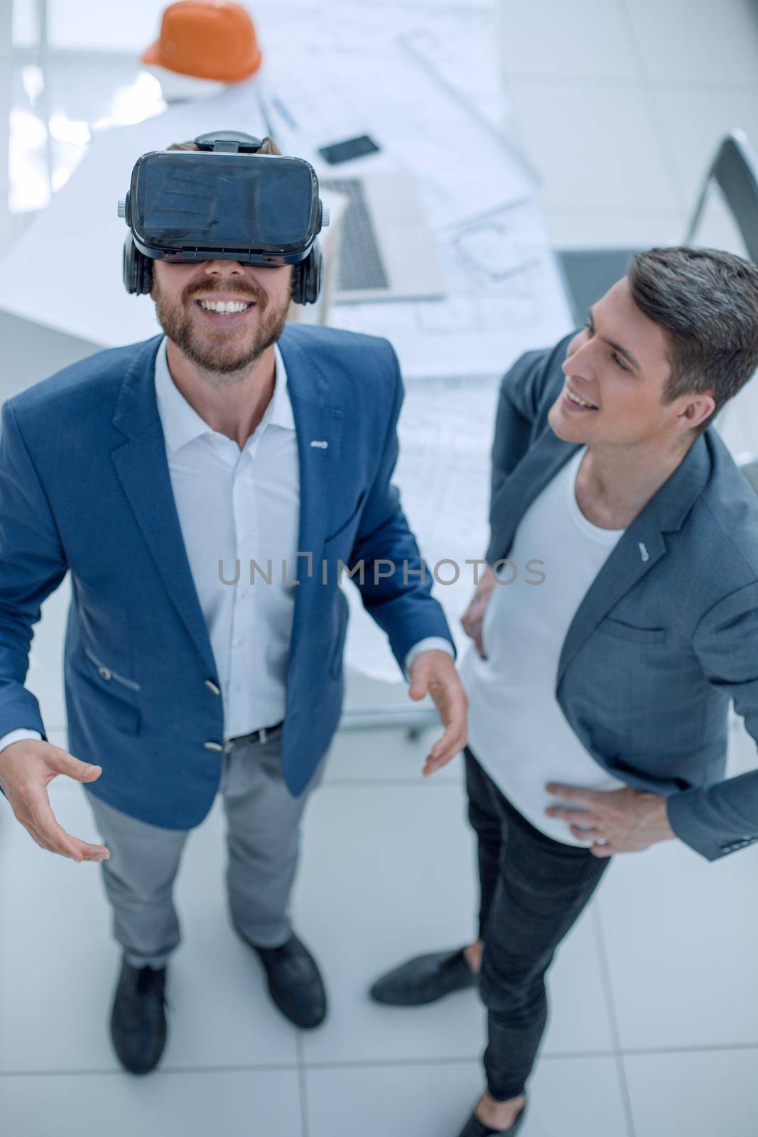 top view. smiling man looking through VR helmet. by asdf