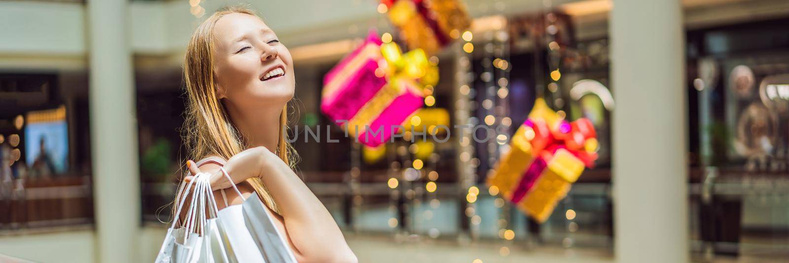 Young woman with purchases in new year shop. Christmas sale, black friday. BANNER, LONG FORMAT