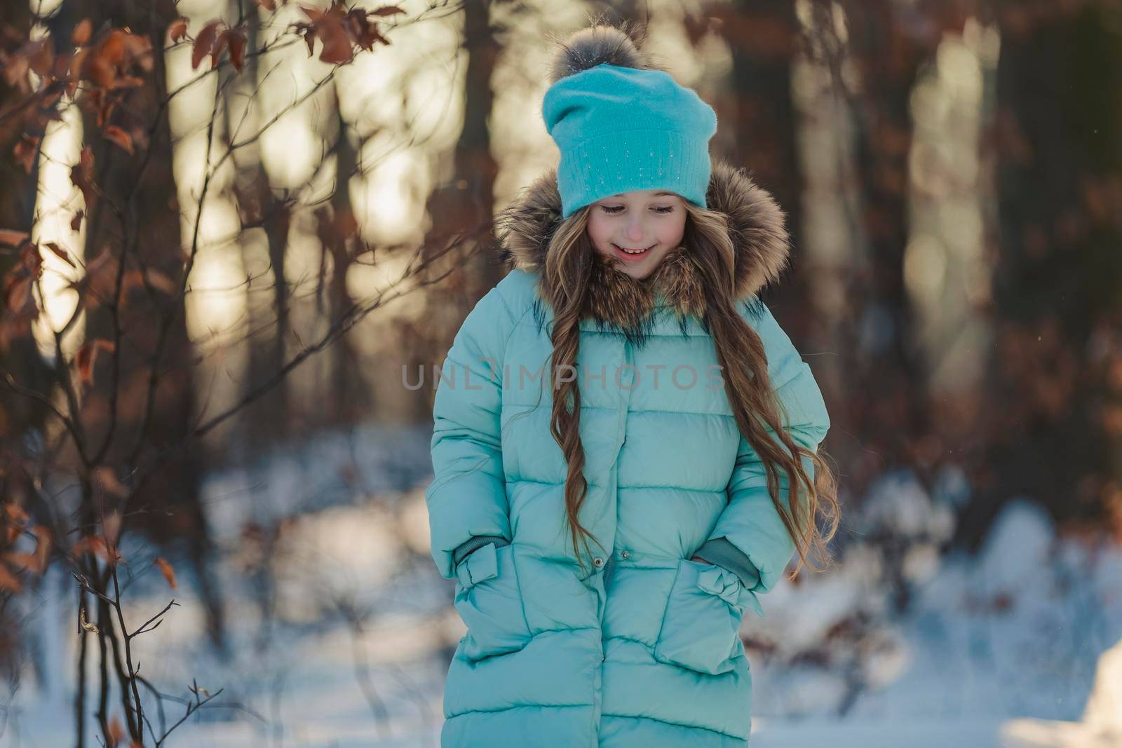 happy girl in turquoise jacket and hat