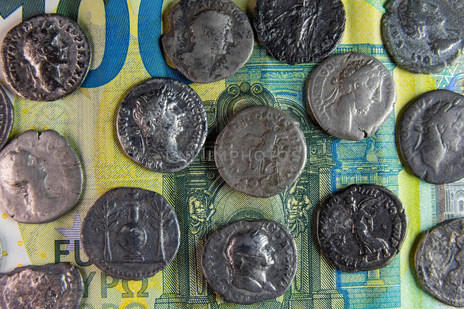 old roman coins on modern stoev banknote closeup