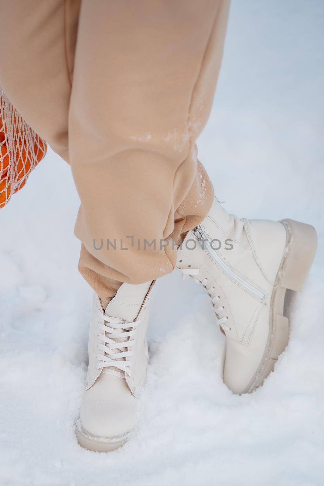 The model demonstrates women's shoes in the snow