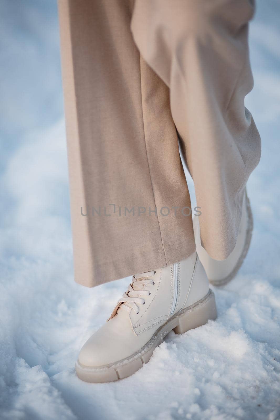 The model demonstrates women's shoes in the snow