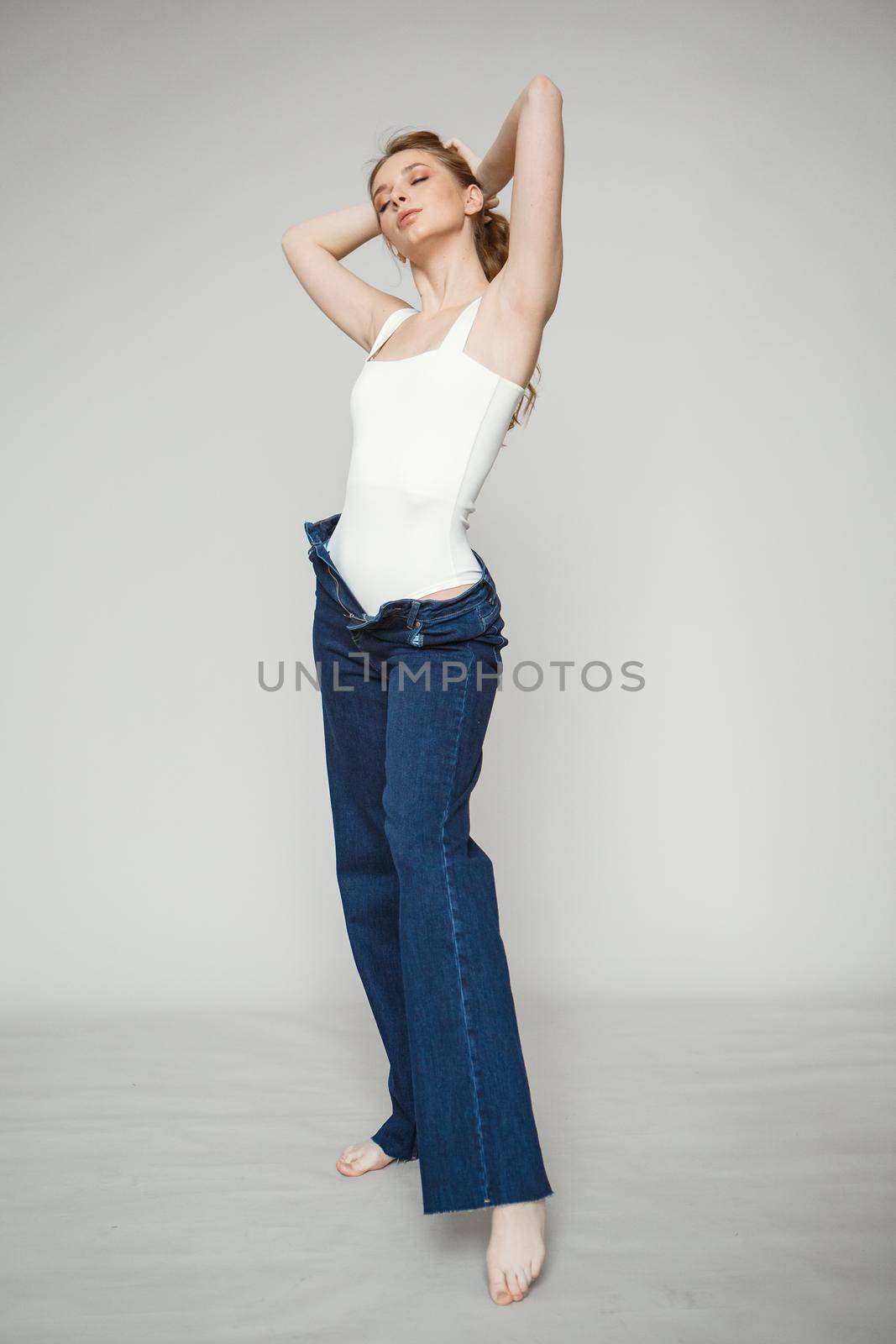 Legs in jeans to beautiful girl. Isolated on background