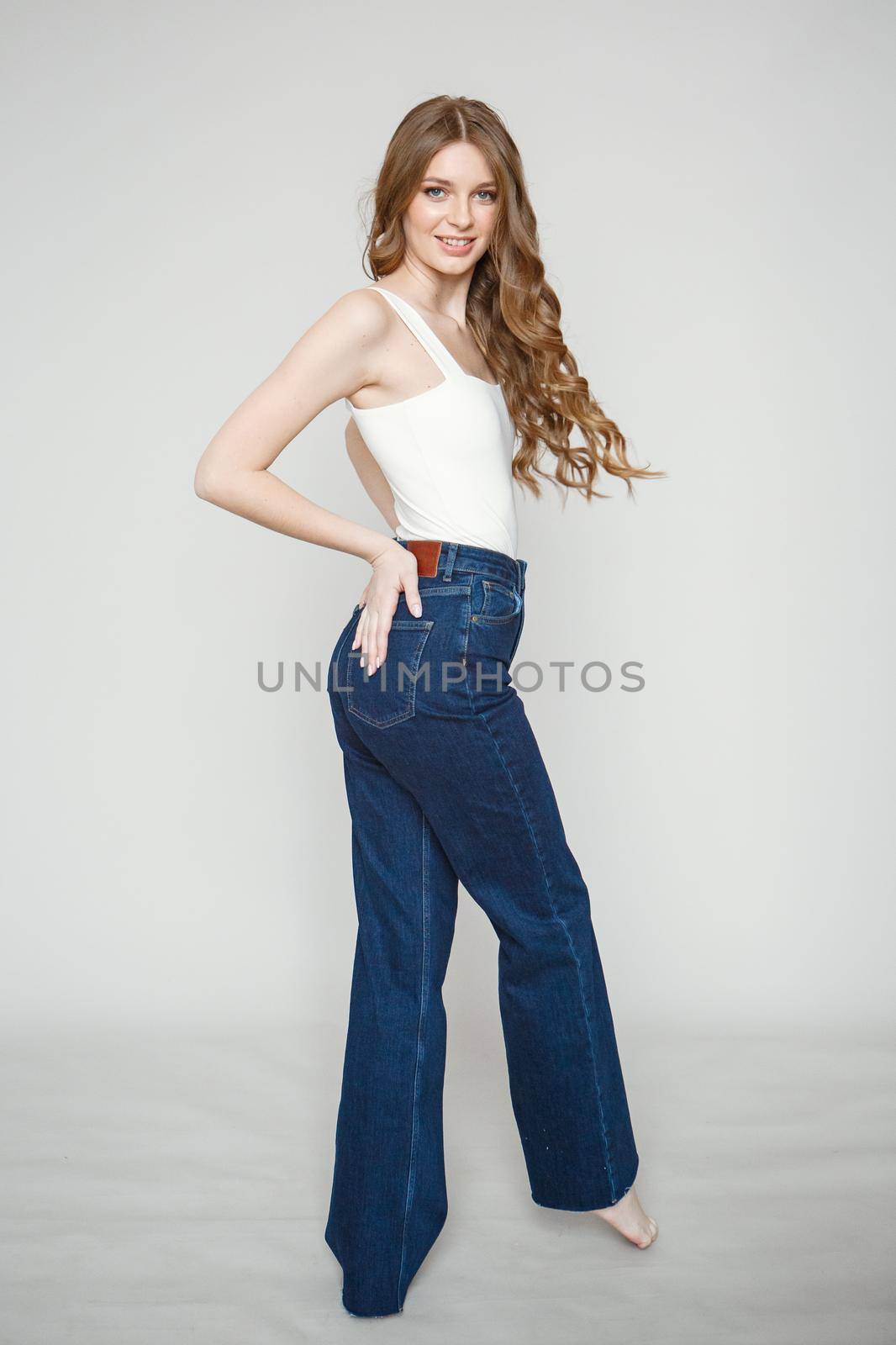 Legs in jeans to beautiful girl. Isolated on background