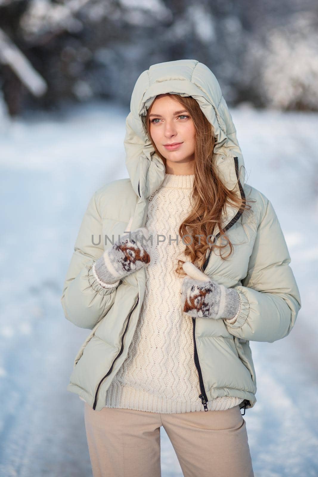 A model girl walking through a snow-covered forest