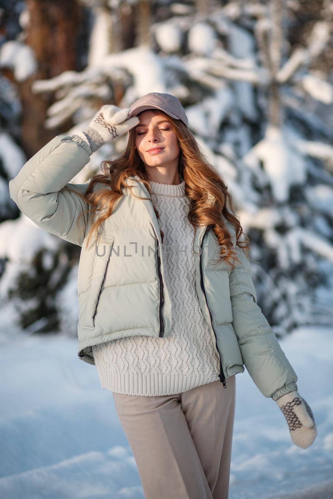 A model girl walking through a snow-covered forest