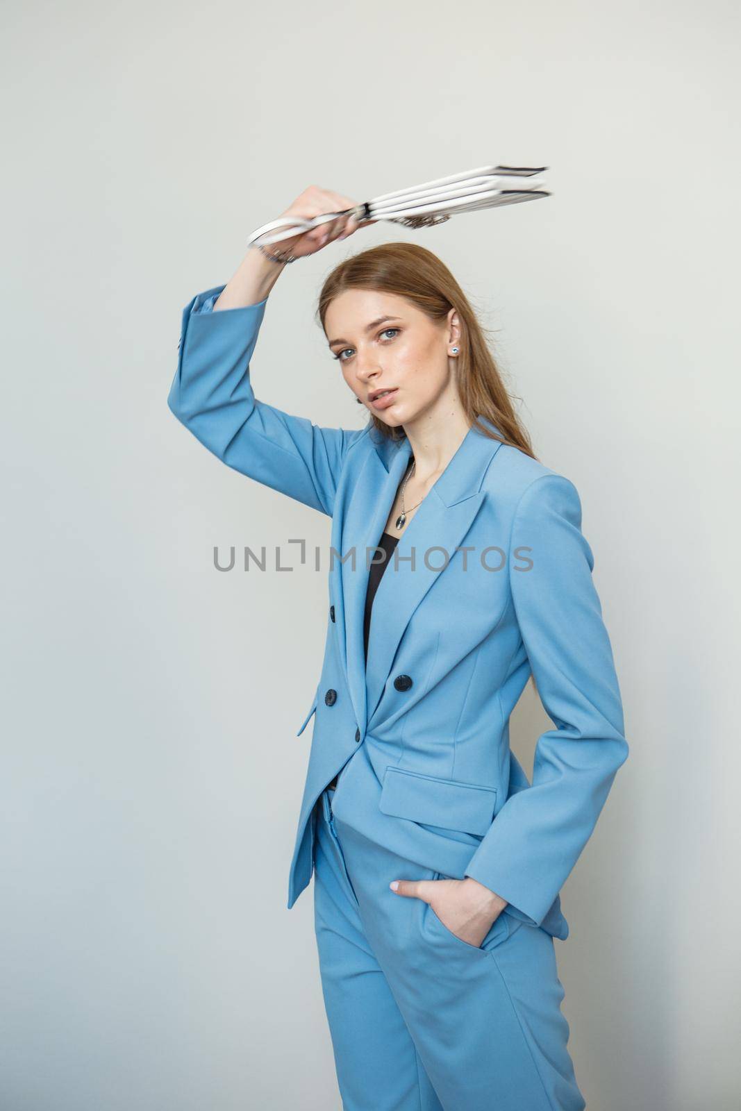 The model is a girl in a blue business suit. Shooting fashionable clothes for the store. Studio background by deandy