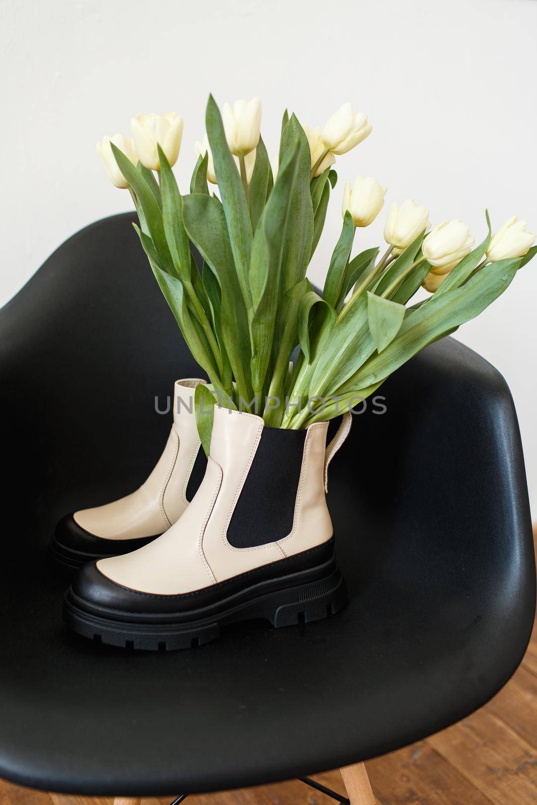 Fashionable shoes that stand on a chair. There are tulips in the shoes. Women's International Day by deandy
