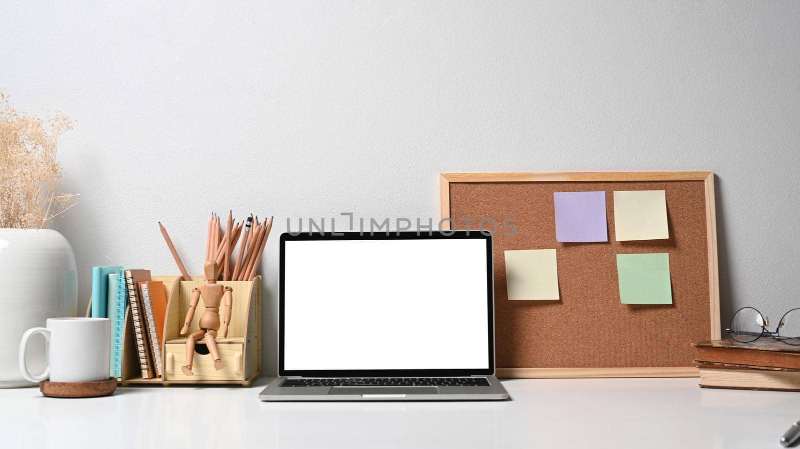 Front view mock up laptop computer coffee cup and stationery on white table. Empty screen for advertise text.