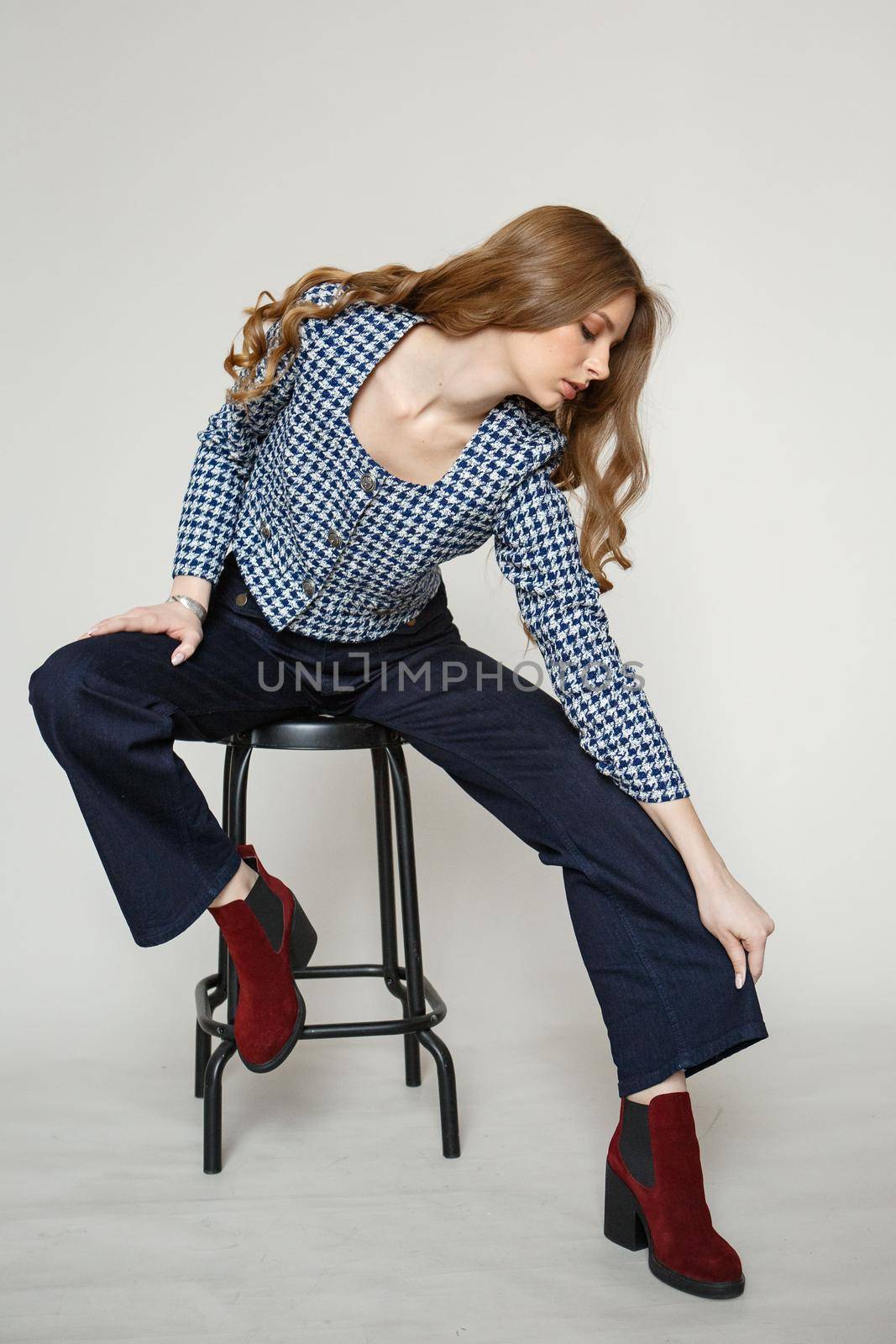 A girl in a denim suit standing on a studio background by deandy