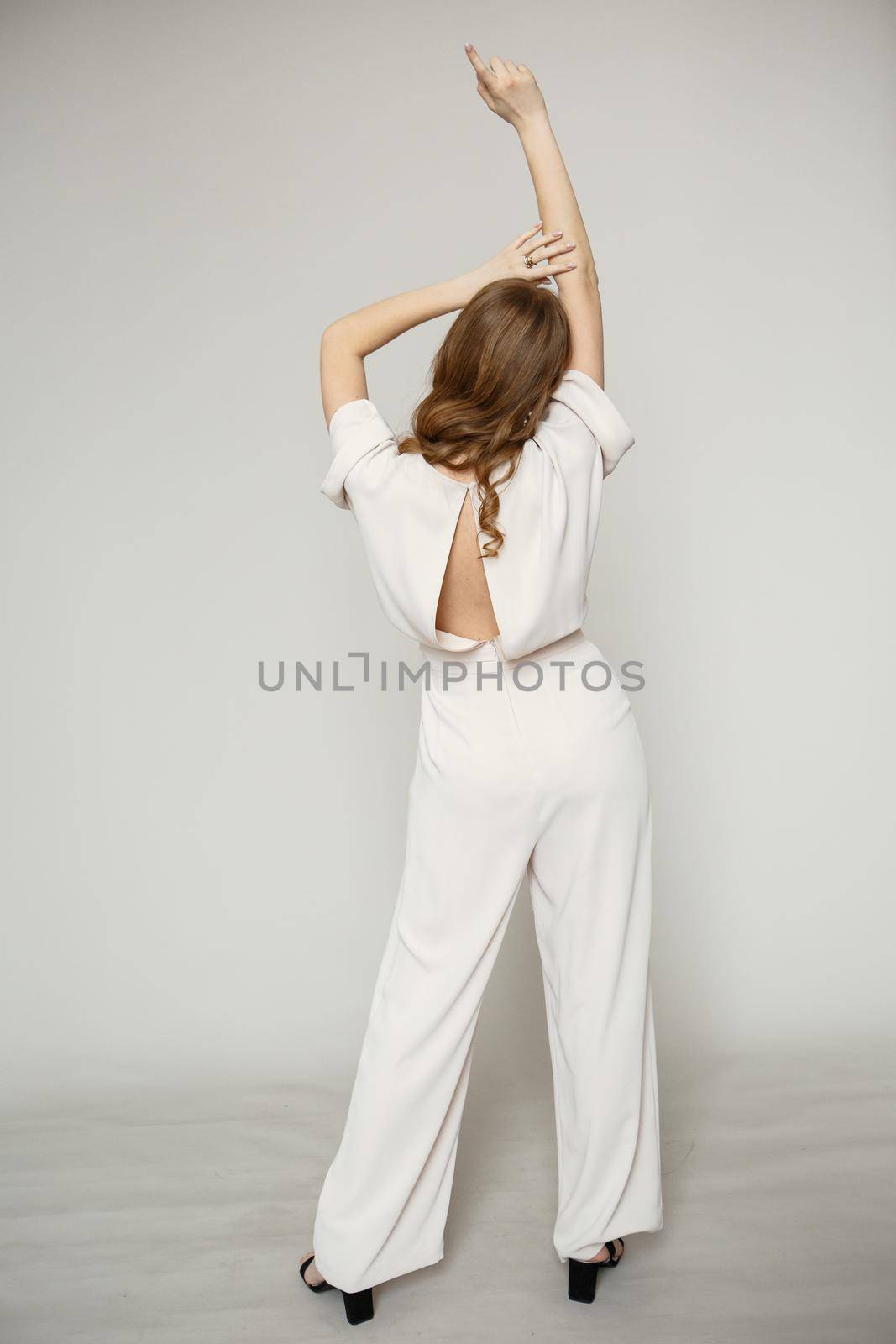 A model in a brown dress suit on a studio background. Shooting fashion clothes by deandy