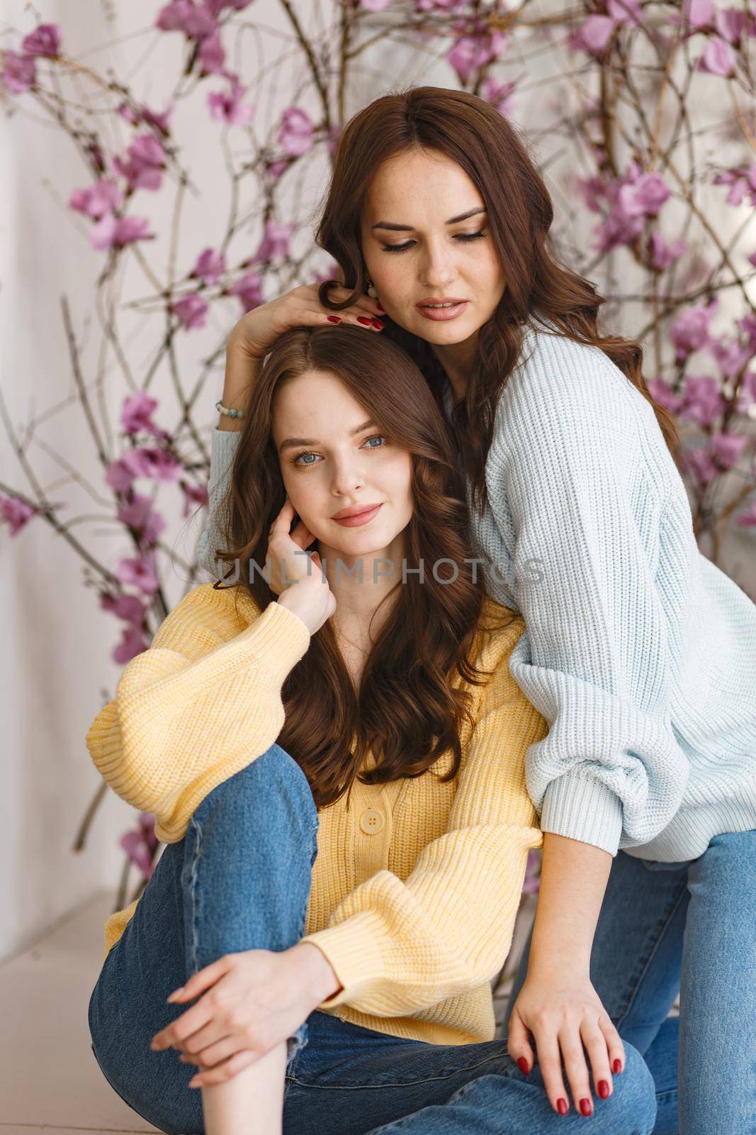 Two girls, models, have fun and smile in a photo studio. Expression of emotions by deandy