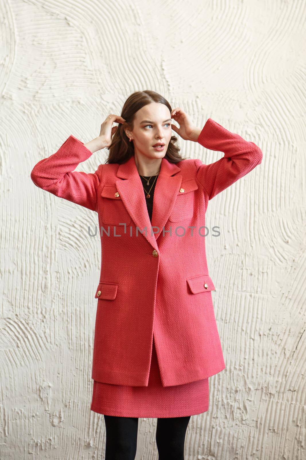 A girl model in pink clothes in the studio. Shooting fashionable clothes for the showroom.