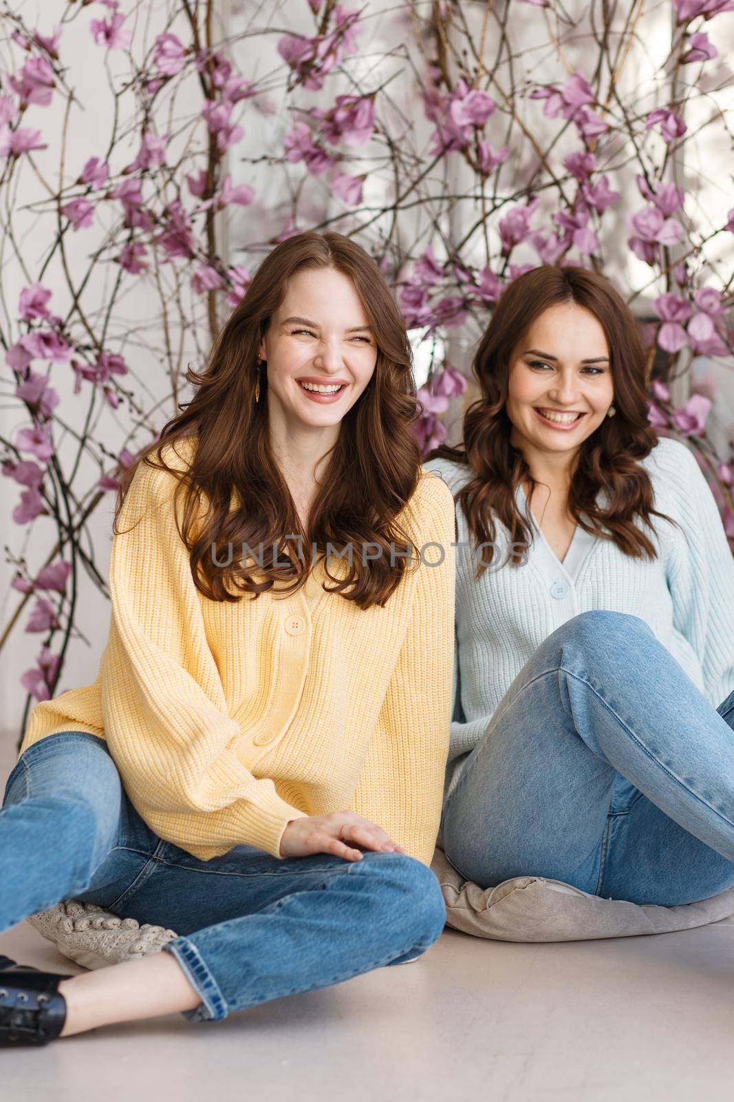 Two girls, models, have fun and smile in a photo studio. Expression of emotions by deandy