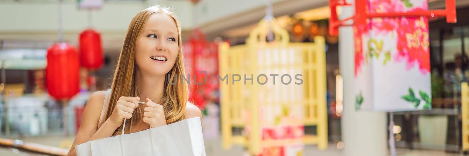 BANNER, LONG FORMAT Woman hold shopping bag against the background of Chinese red lanterns for the Chinese New Year. Big sale in honor of the New Year's Eve. Black Chinese Friday 11.11.