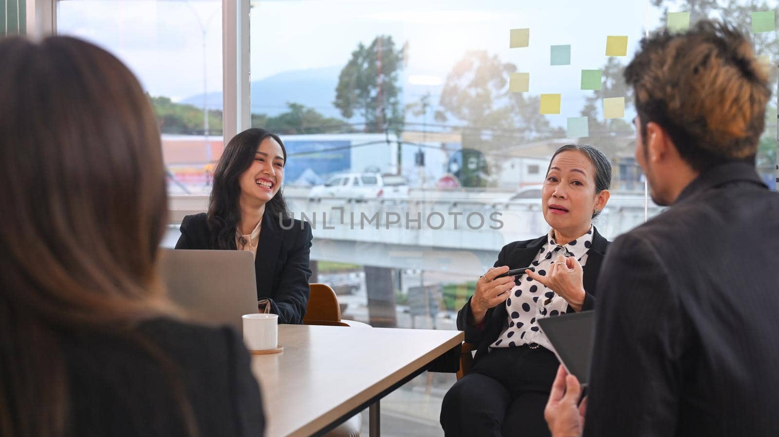 Attractive female business leader discussing new ideas with employees in a conference room.