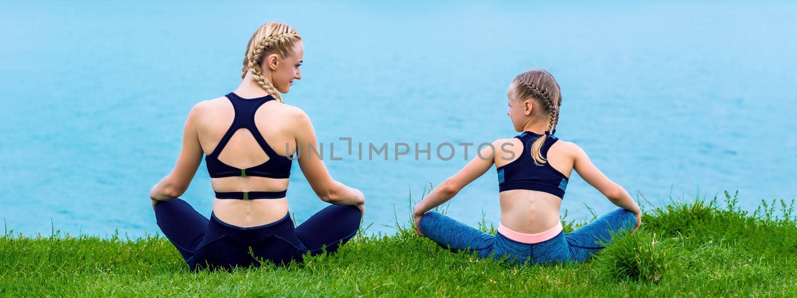 Mother and daughter doing yoga exercises by okskukuruza