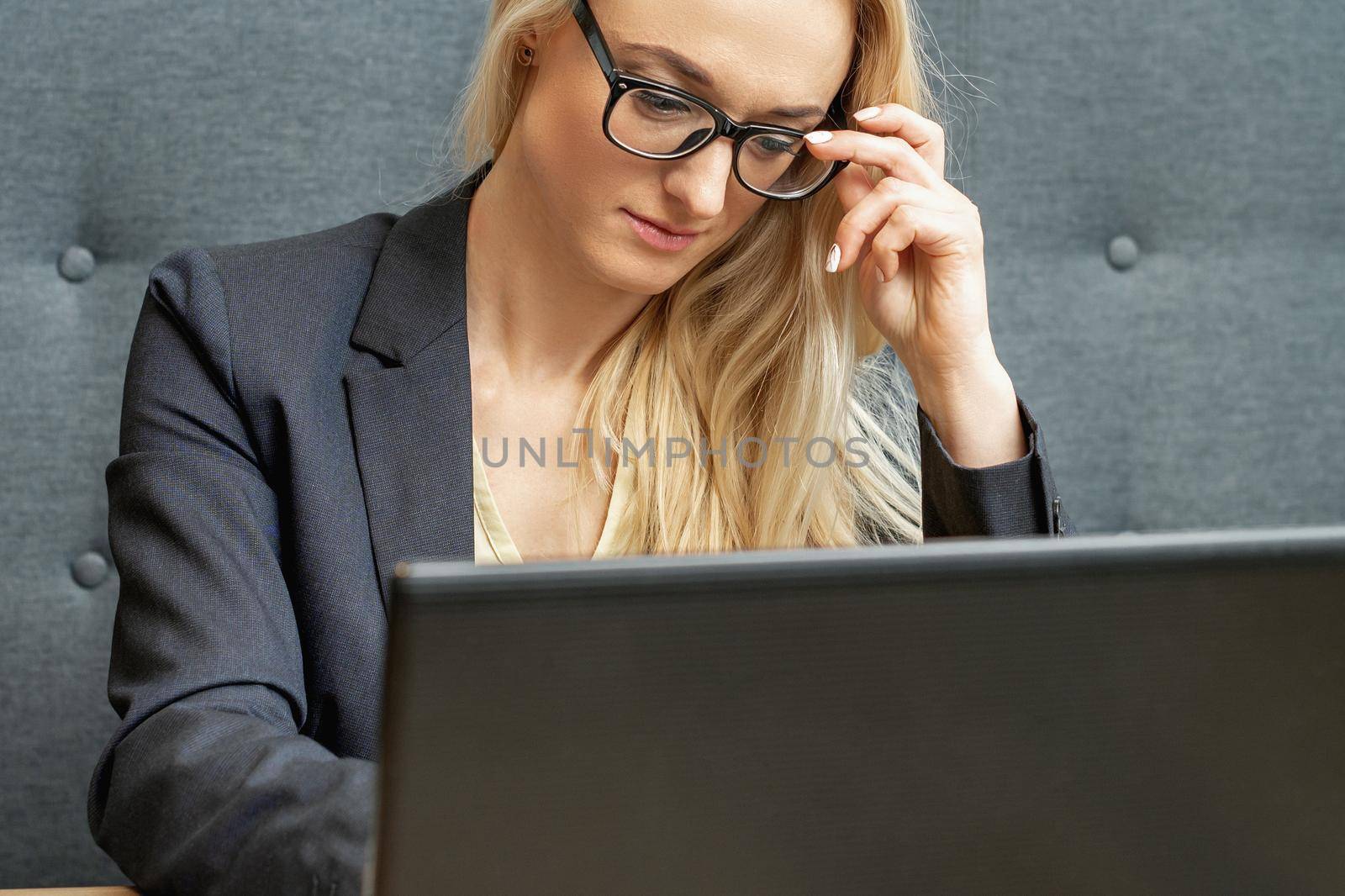 Woman is working on laptop at home office. by okskukuruza