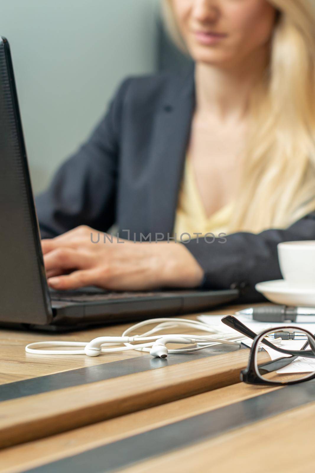 Eyeglass with coffee on office table on female business worker background.