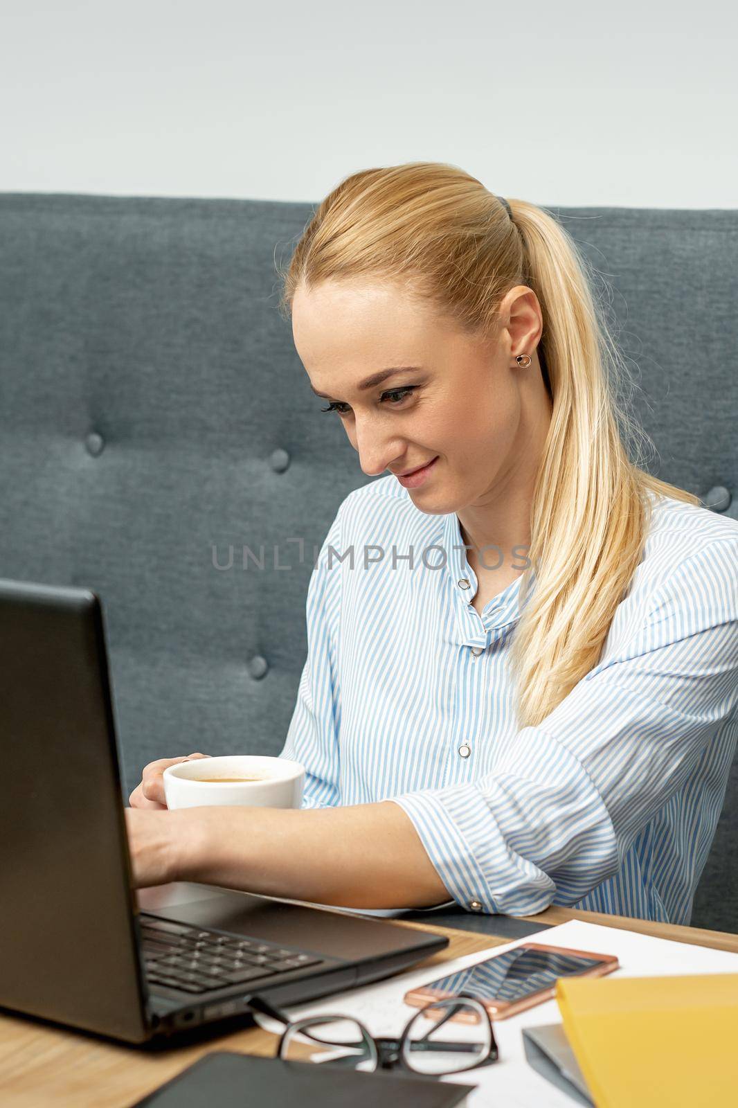 Woman is working on laptop at home office. by okskukuruza