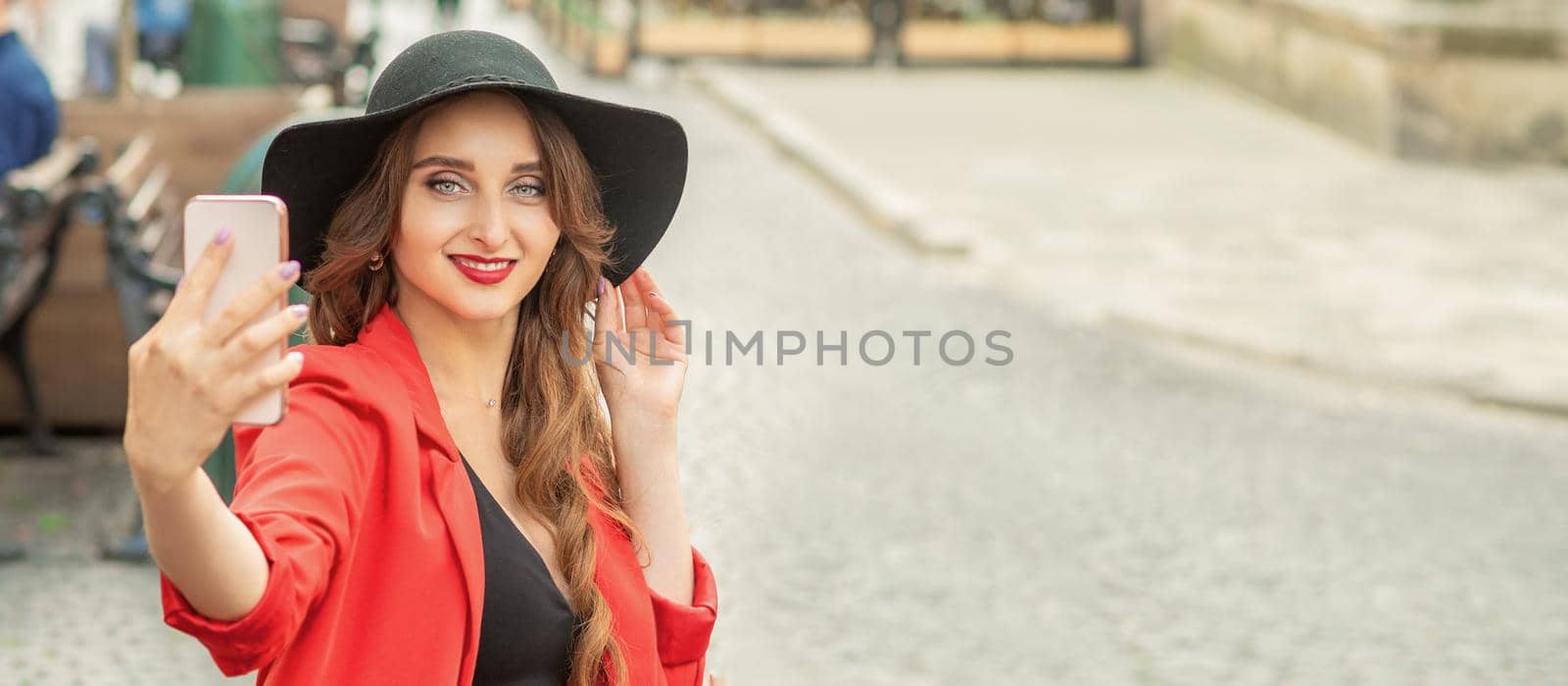 Pretty woman traveler taking selfie portrait by smartphone walking on the city street.