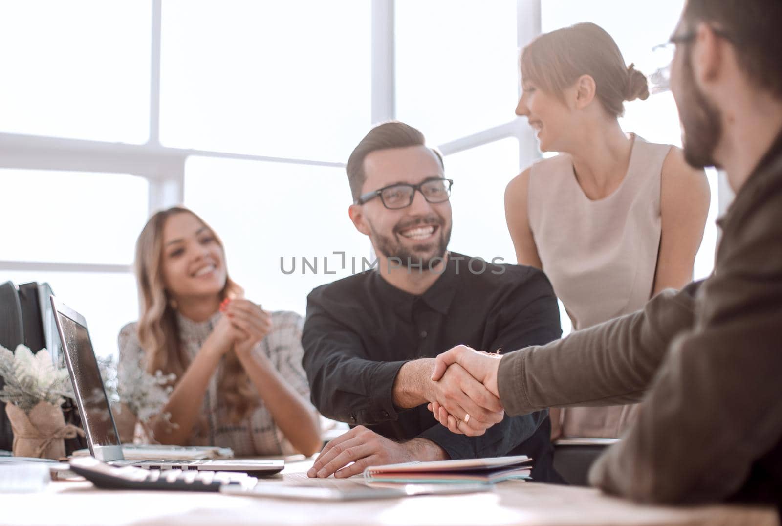 background image of the handshake of business partners in the office. business concept