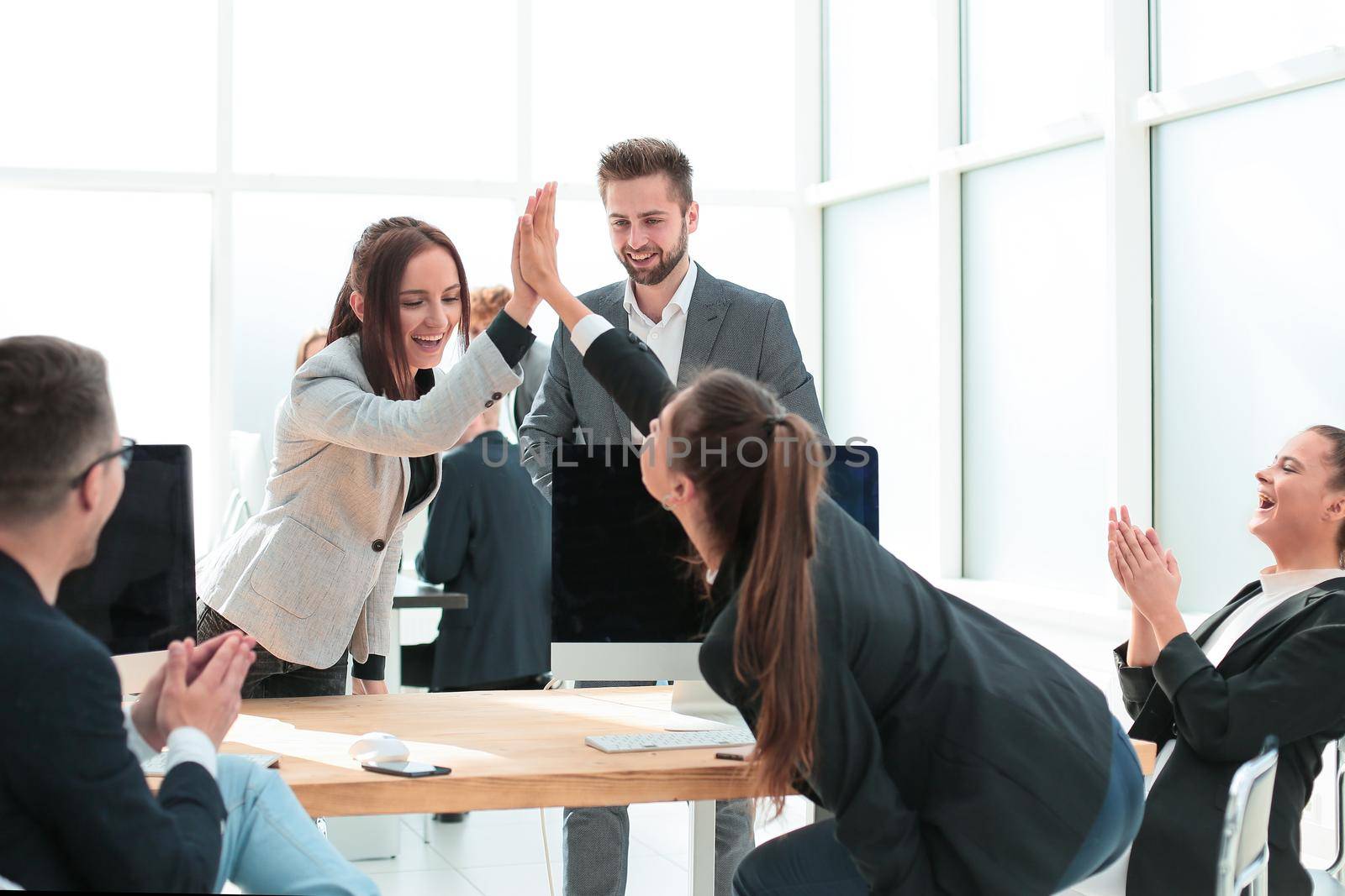 young employees giving each other a high five. the concept of successful work