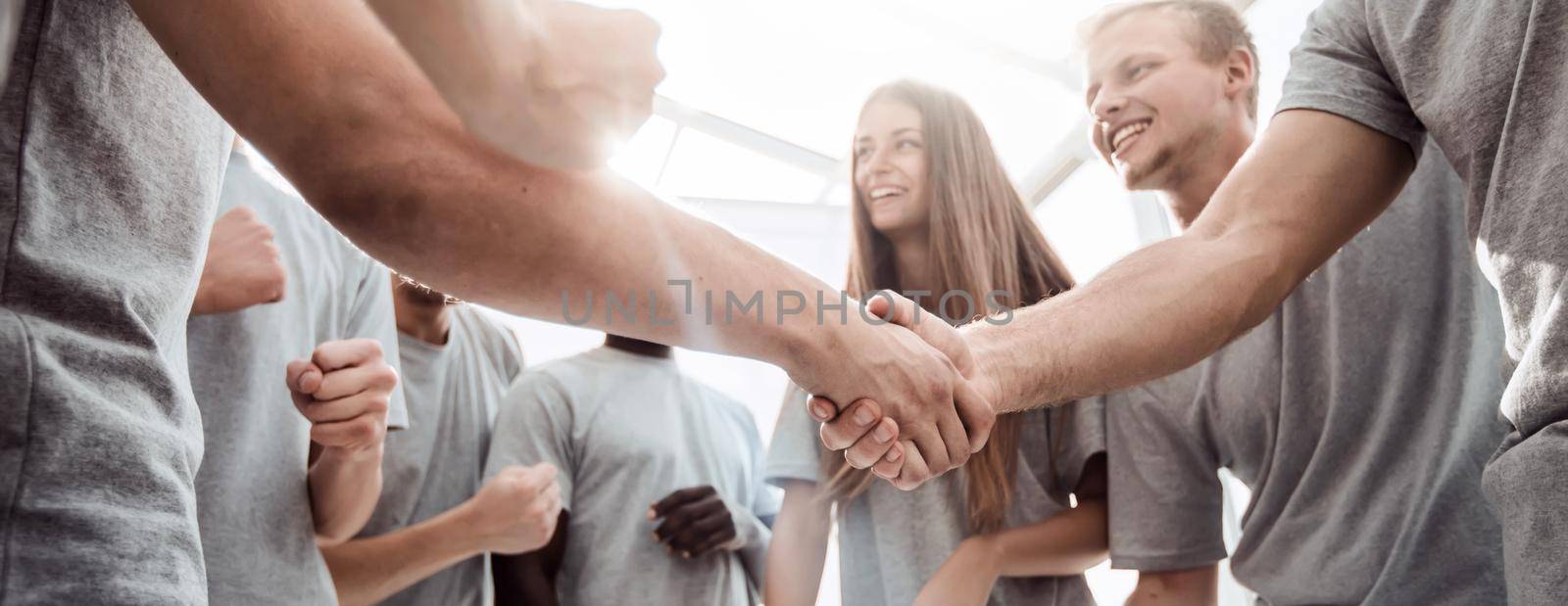 bottom view. handshake of young people in a circle of friends