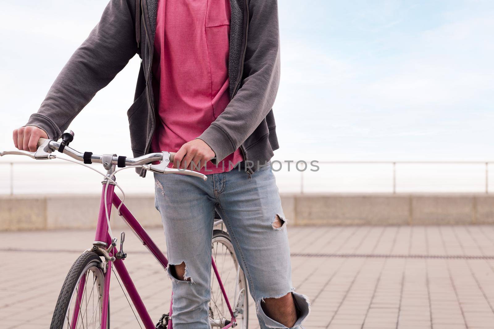 unrecognizable young man walking with a vintage bike, concept of sustainable transportation and urban lifestyle, copy space for text