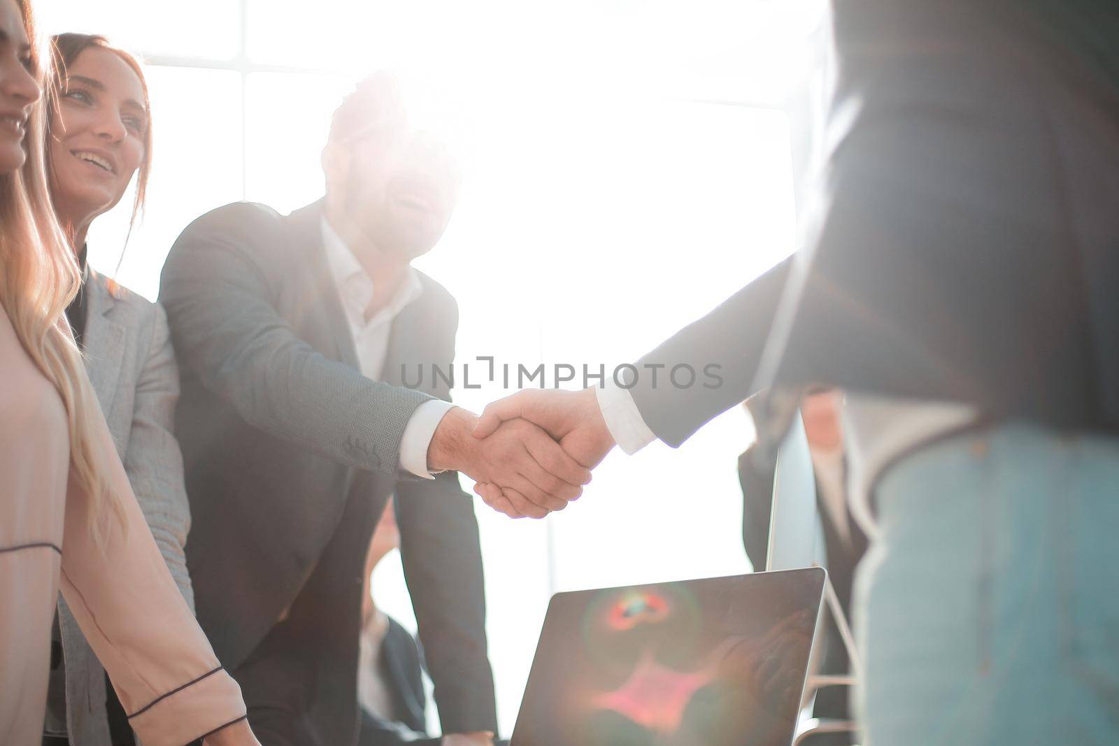 happy employees shaking hands in the workplace. the concept of successful work