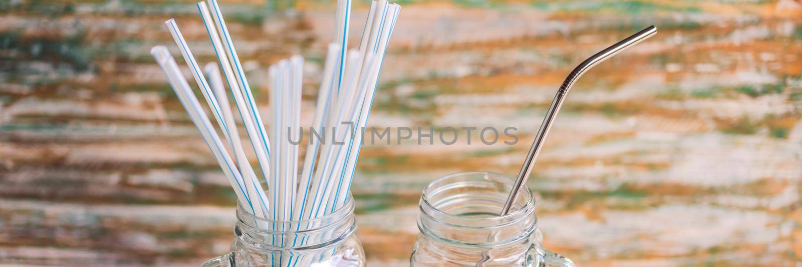 Steel drinking vs disposable straws on painted wooden background. Zero waste concept. BANNER, LONG FORMAT