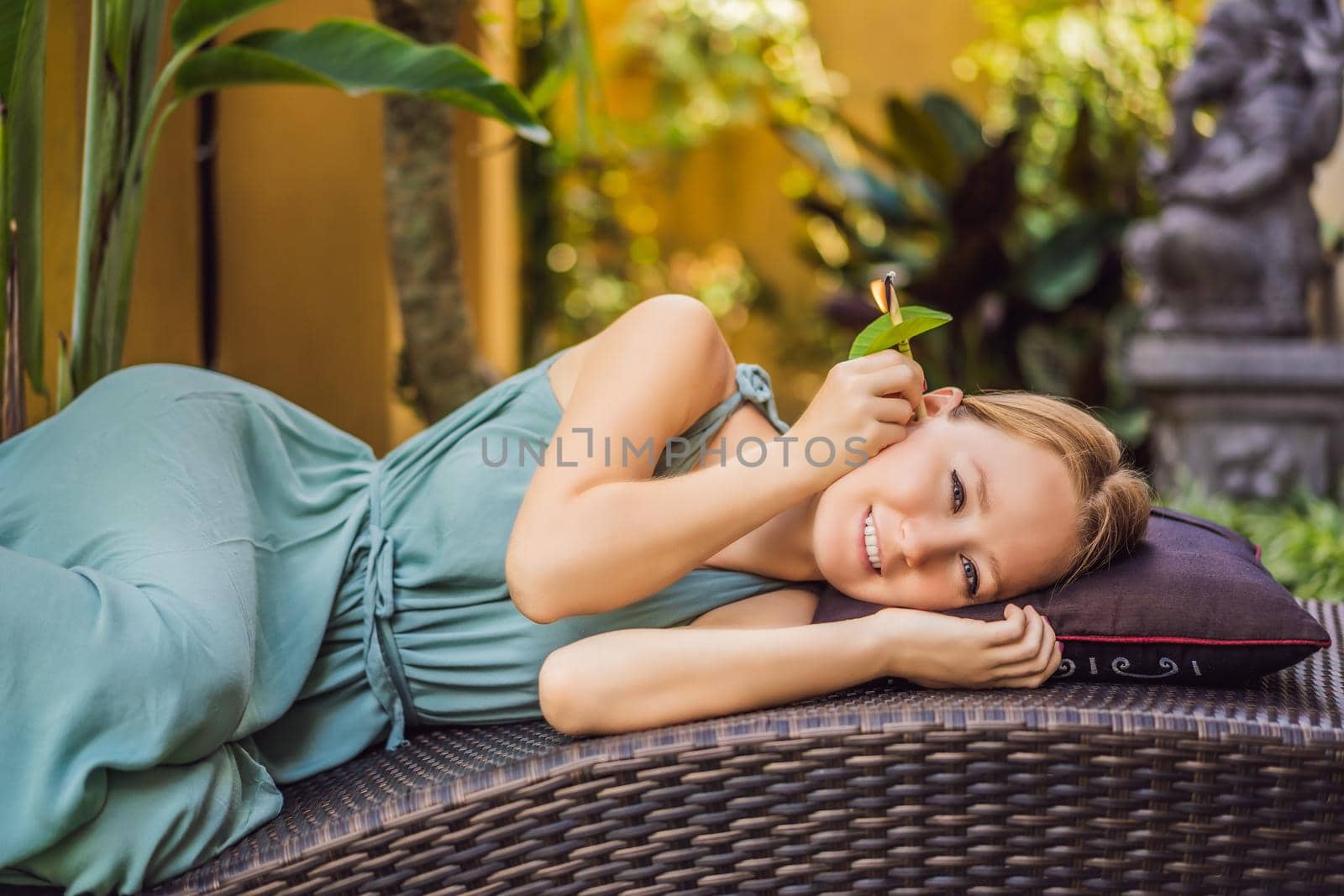 Ear candling being carried out on an attractive caucasian woman in a spa.