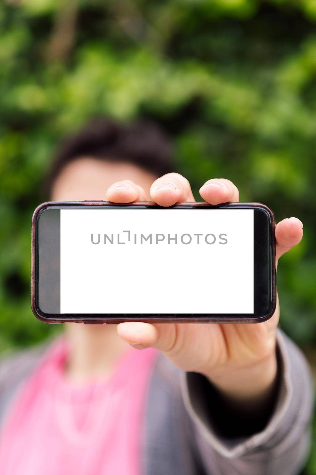 vertical photo of an unrecognizable man showing a smart phone with blank screen, concept of technology, copy space for image or text