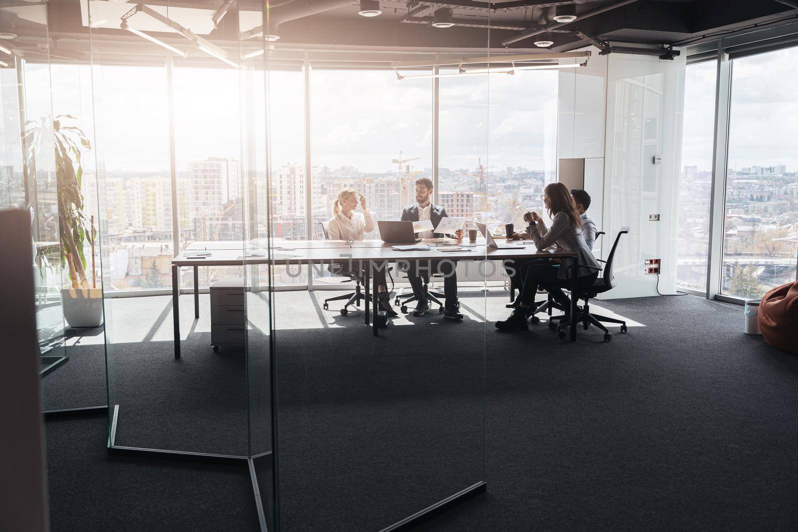 Team of businessmen communicating together in modern office with panoramic windows by Yaroslav_astakhov