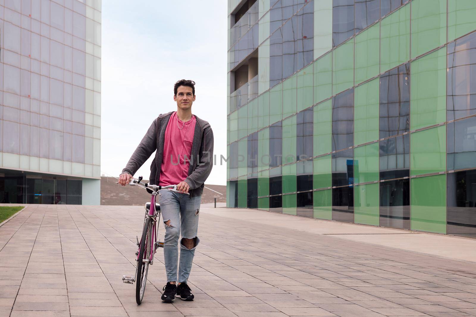 young man walking through the city with a retro bicycle, concept of sustainable urban transportation and ecological lifestyle, copy space for text