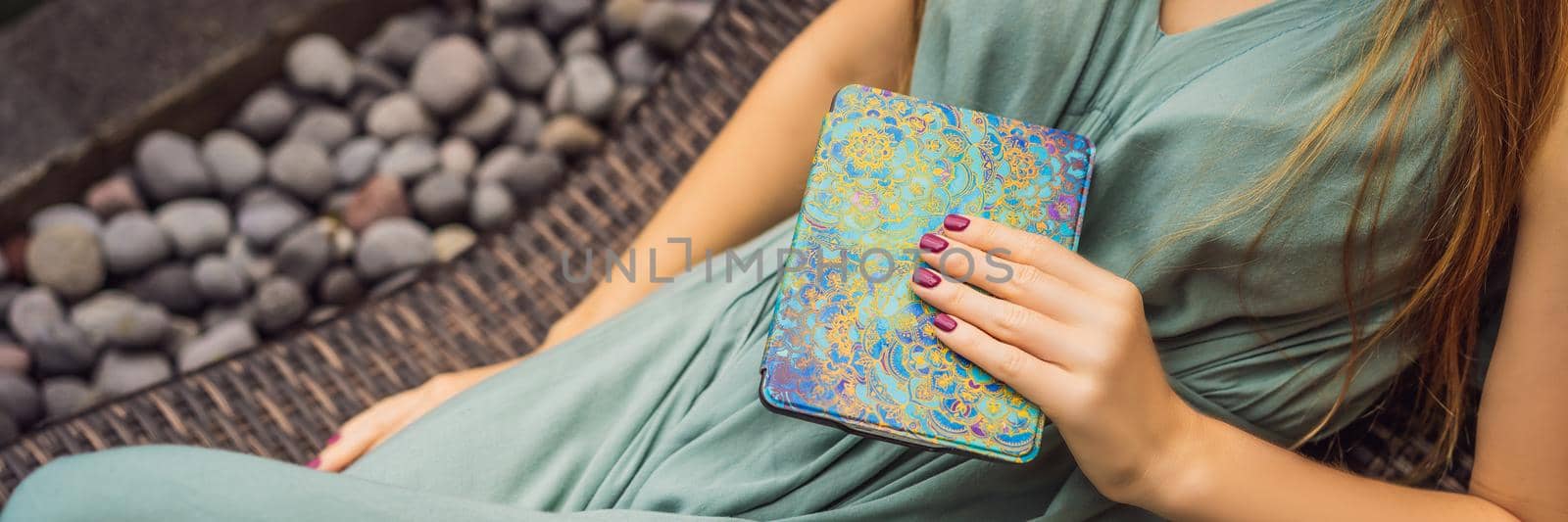 Woman reads e-book on deck chair in the garden BANNER, LONG FORMAT by galitskaya