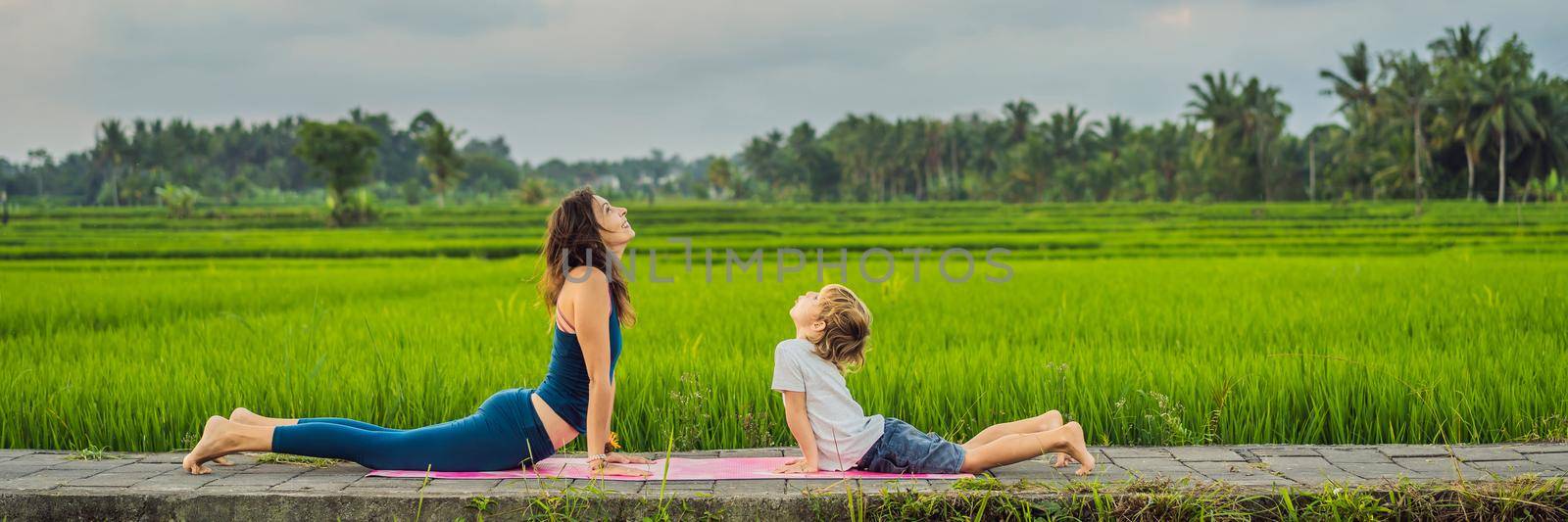 Boy and his yoga teacher doing yoga in a rice field. BANNER, LONG FORMAT