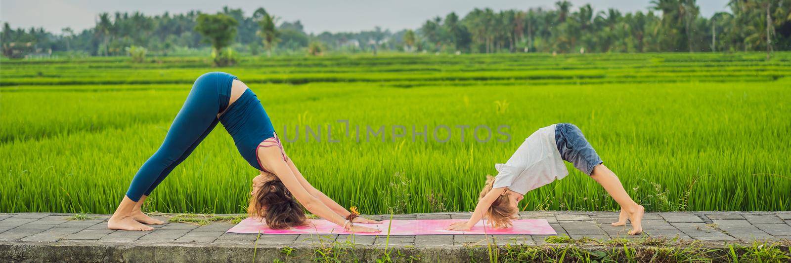 Boy and his yoga teacher doing yoga in a rice field. BANNER, LONG FORMAT