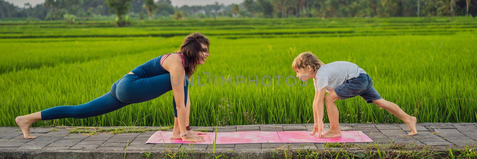 Boy and his yoga teacher doing yoga in a rice field BANNER, LONG FORMAT by galitskaya