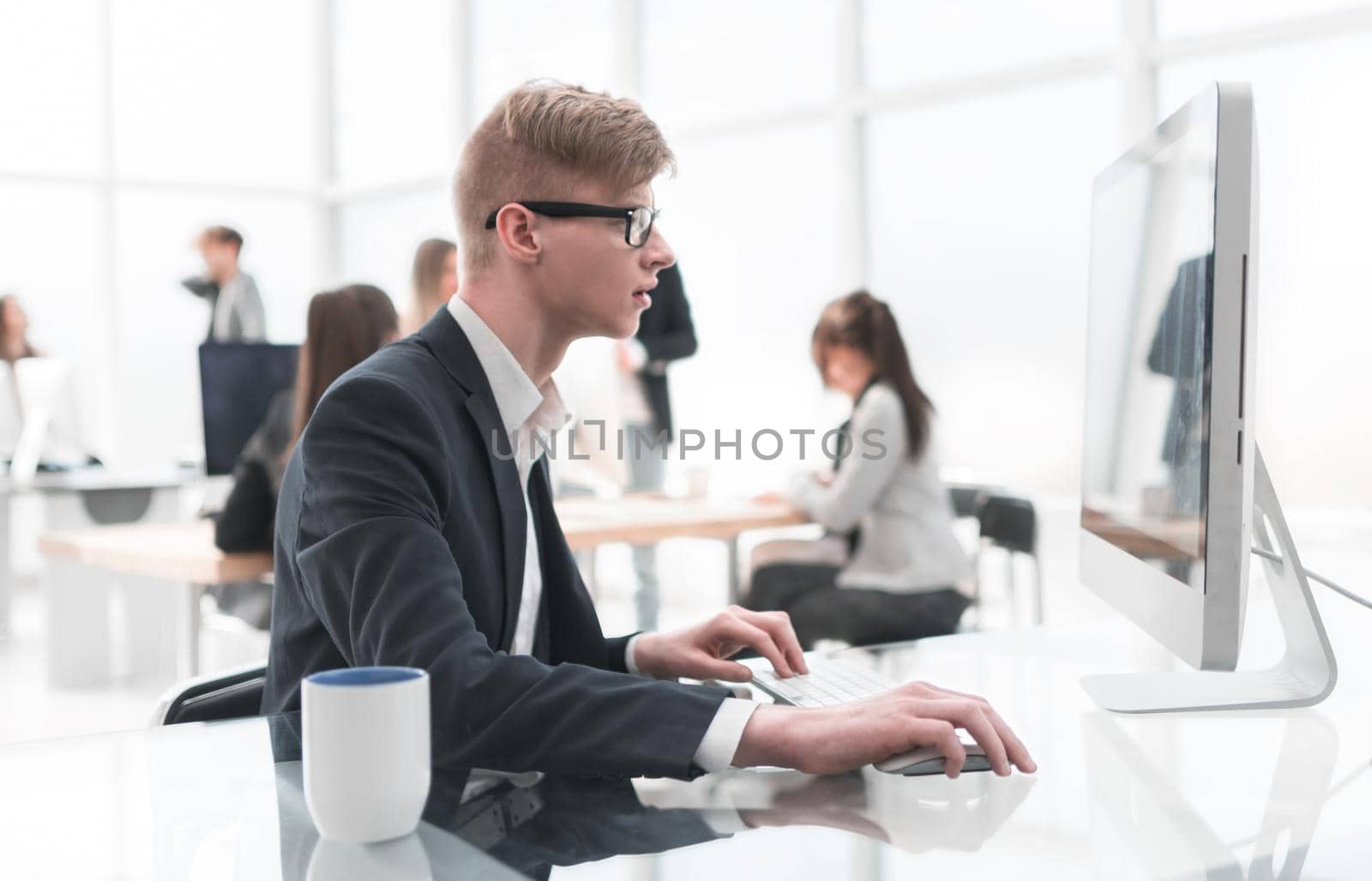 confident young employee in the workplace in the office. people and technology