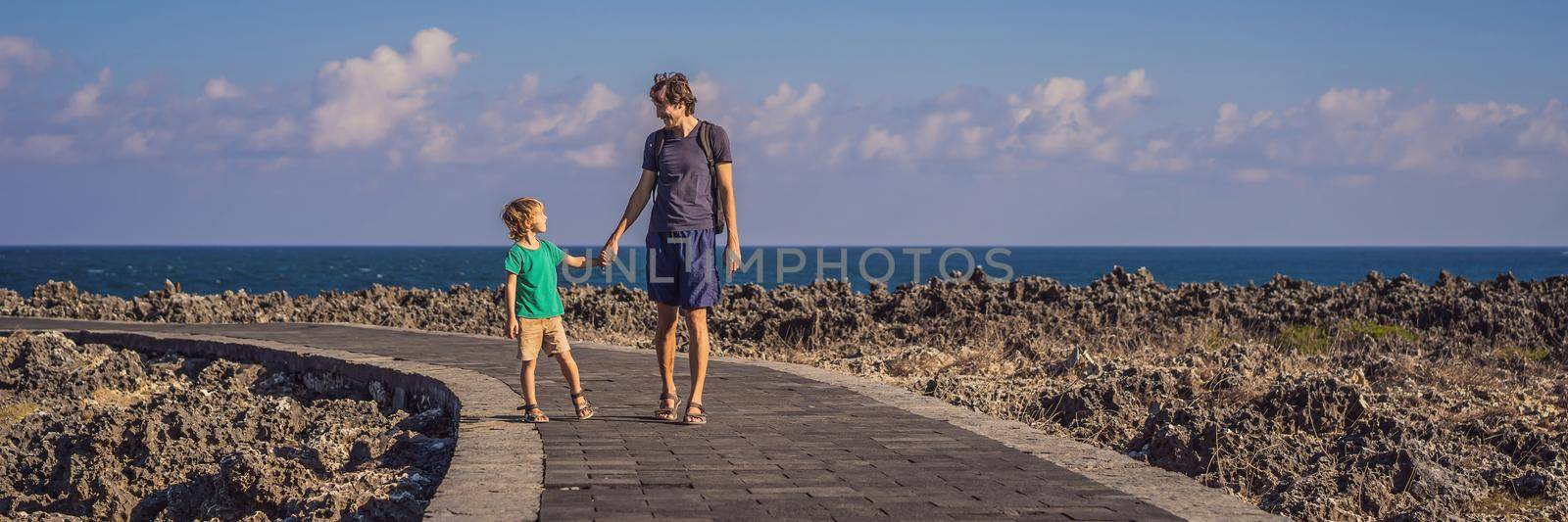 Father and son travelers on amazing Nusadua, Waterbloom Fountain, Bali Island Indonesia. Traveling with kids concept. BANNER, LONG FORMAT