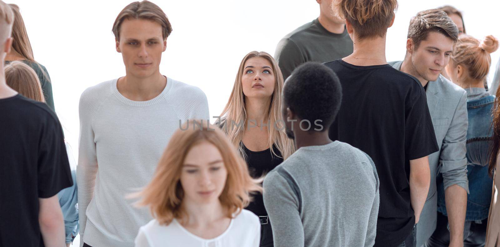image of a serious woman standing in front of a casual group of young people.