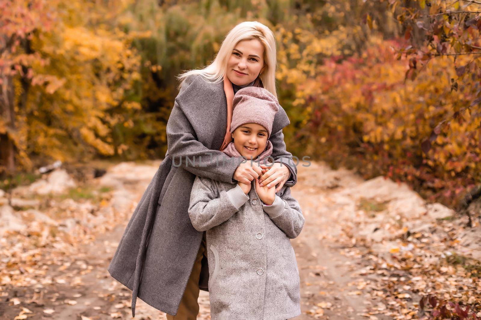 Mother and daughter in autumn yellow park