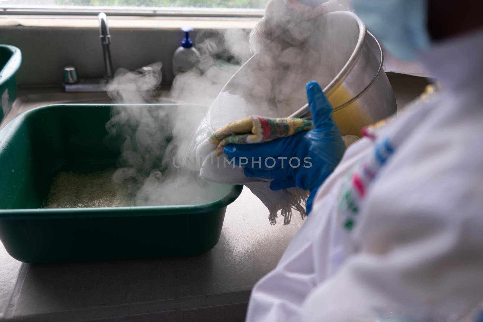 Precooking process for the production of medicinal mushrooms in a laboratory. Latina scientist puts boiling water during a chemical process