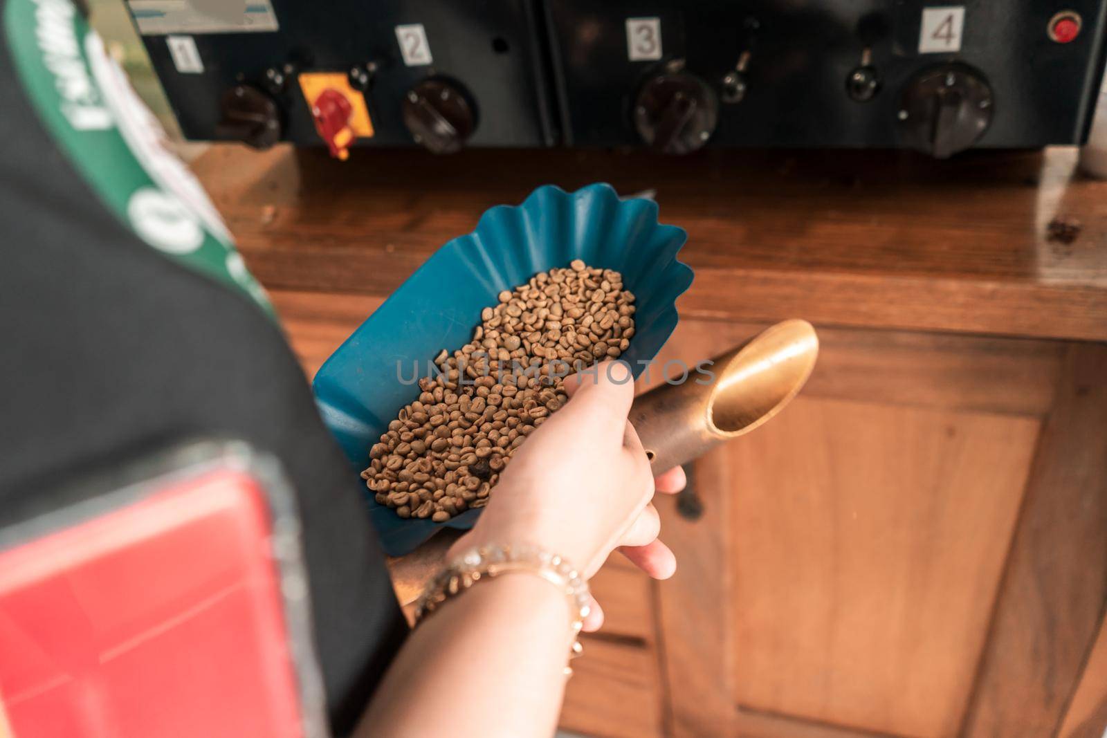 Close up of a professional coffee cupper's hand holding a tray and dispenser for roasting beans
