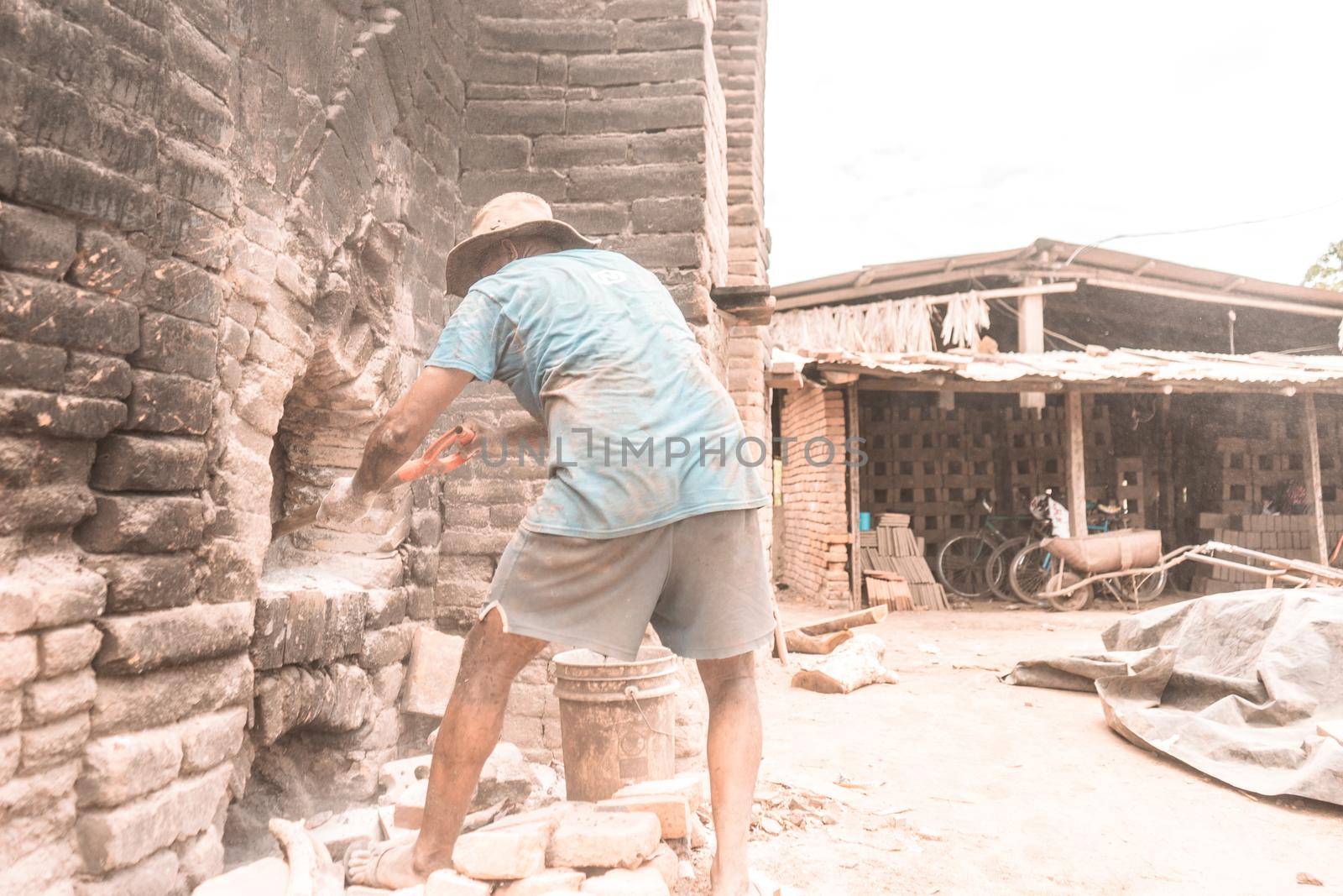 Worker seen from behind lighting a brick kiln to make clay blocks and tiles in La Paz Centro Nicaragua