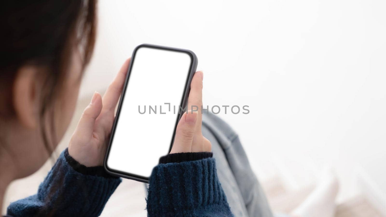 Top view of woman hands holding smart phone with blank copy space screen for your text message or information content. by wichayada