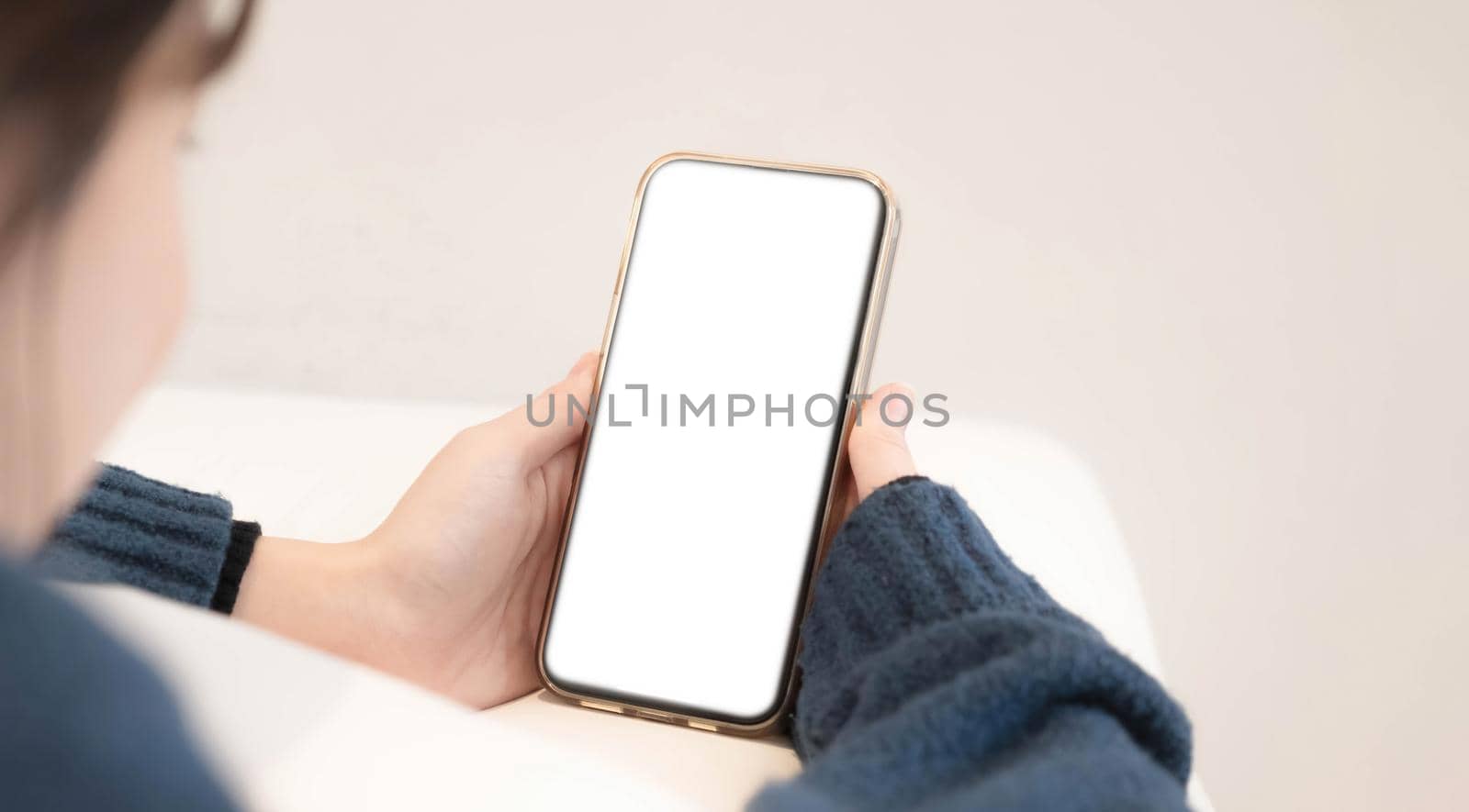 Top view of woman hands holding smart phone with blank copy space screen for your text message or information content..